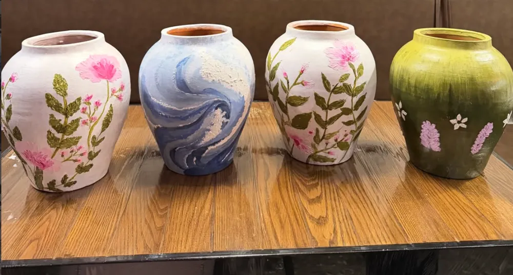 Four hand-painted pots with floral, ocean-blue and green designs