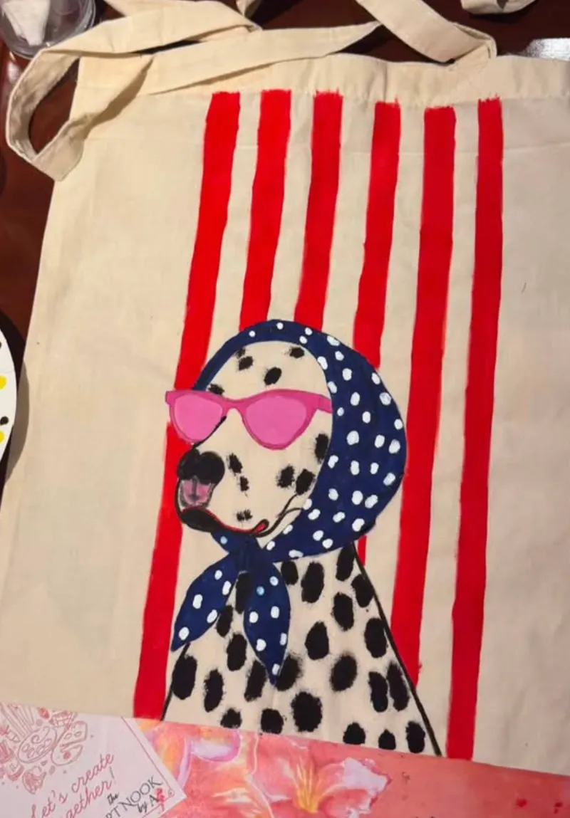 A hand-painted Dalmatian tote with pink sunglasses and red stripes